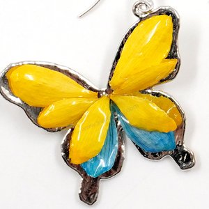 Silver plated Bird's Nest Fern cut into butterfly shape as base is layered with delicate flower Petals in assorted colors in 3D style; preserved in flexible, clear coating. Flower Petal colors can be changed.